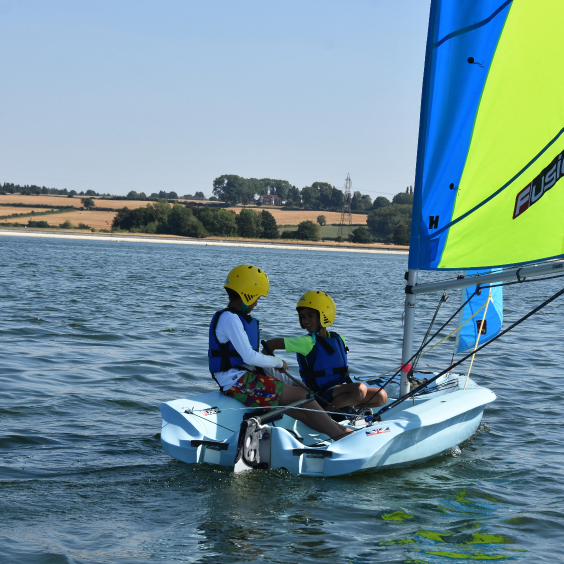 Two youths in a sailing boat.