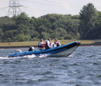 Three persons having a ride in a powerboat.