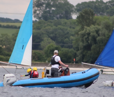 Someone powerboating while others sail.