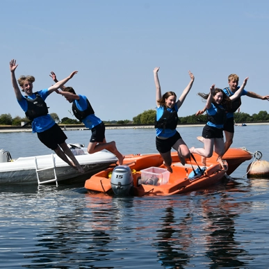 Young people jumping off from boats.