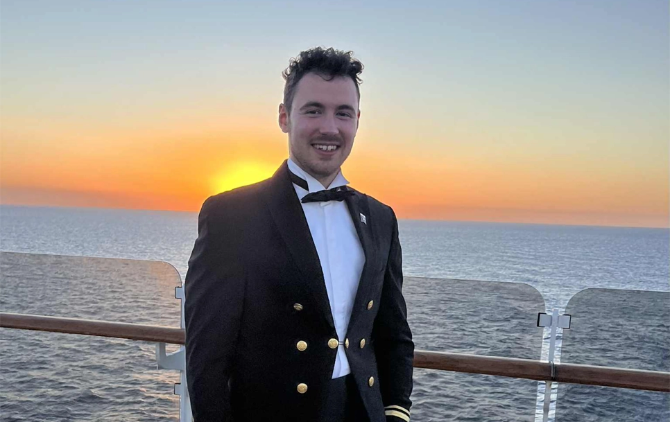 Nathan on a boat with a sunset.